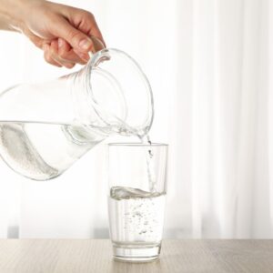 pouring-purified-fresh-water-from-the-jug-in-glass-2023-11-27-05-20-03-utc